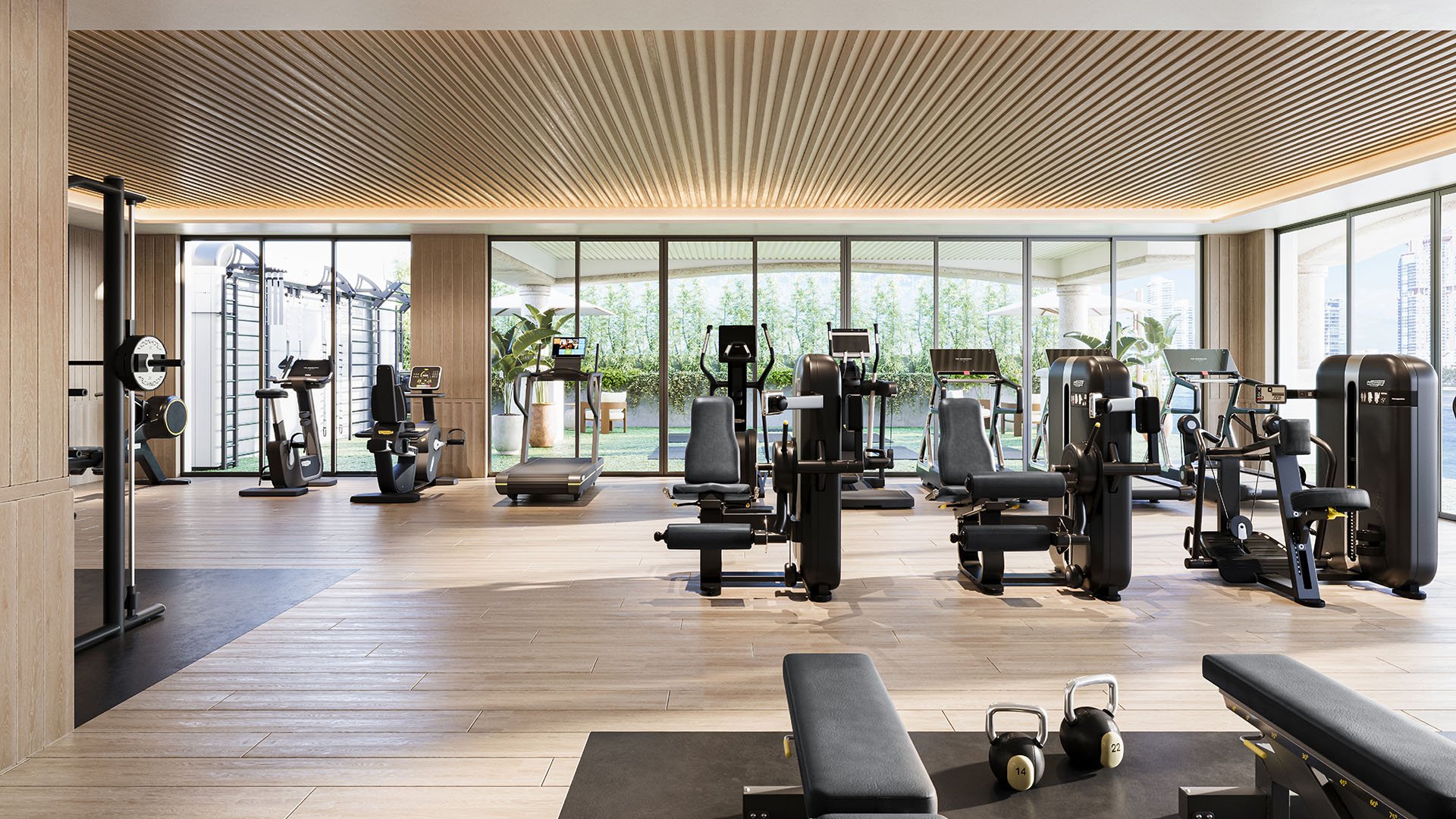 Private gym interior at The Residences at Six Fisher Island, Fisher Island Miami Beach, Florida, with strength-training machines, kettlebells and cardio stations in a glass-walled studio, supporting luxury and ultra luxury preconstruction condos living.
