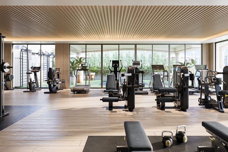 Private gym interior at The Residences at Six Fisher Island, Fisher Island Miami Beach, Florida, with strength-training machines, kettlebells and cardio stations in a glass-walled studio, supporting luxury and ultra luxury preconstruction condos living.
