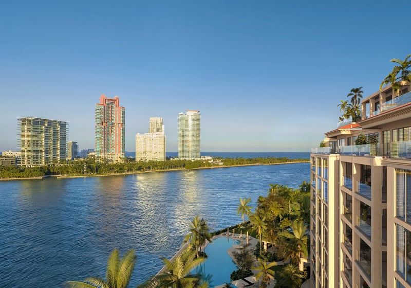 Hummingbird residence balcony view at The Residences at Six Fisher Island, Fisher Island Miami Beach Florida, overlooking Biscayne Bay and skyline; luxury and ultra luxury preconstruction condos with waterfront pool below.
