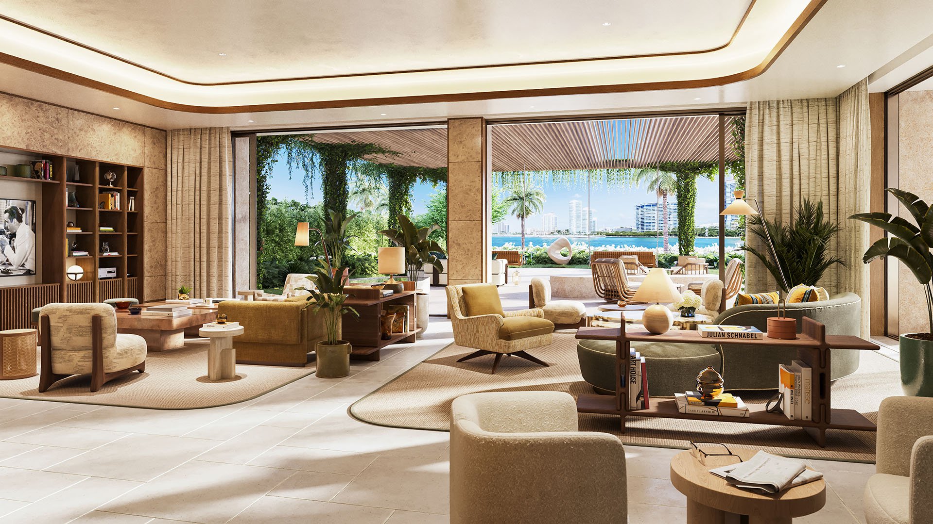 Waterfront living room at The Residences at Six Fisher Island, Fisher Island Miami Beach Florida, built-in bookcase and designer seating opening to terrace; luxury and ultra luxury preconstruction condos with Biscayne Bay views.