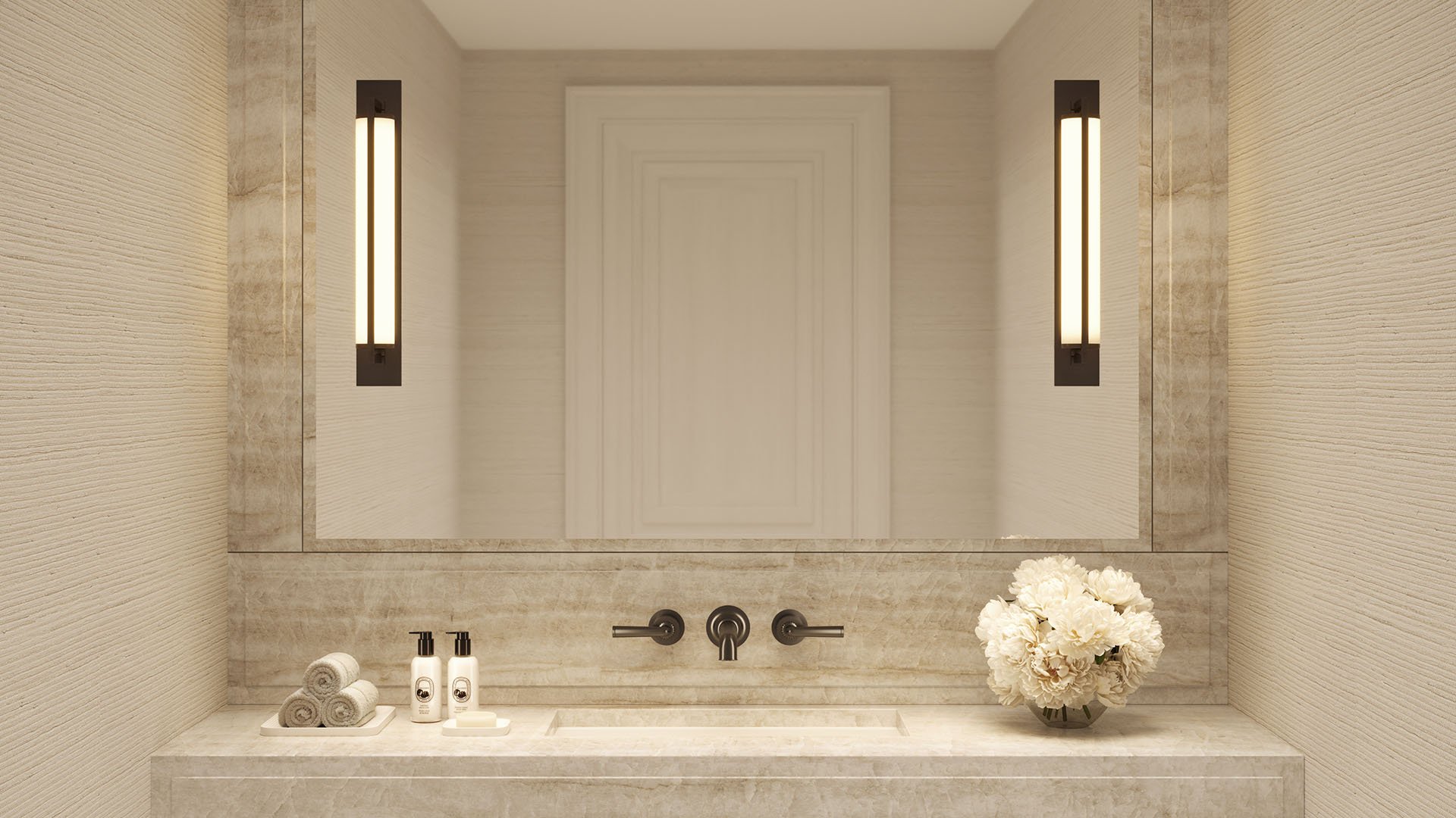 Bathroom vanity detail at The Ritz-Carlton Residences, Fort Lauderdale, with a stone sink, framed mirror, wall sconces, and soft neutral textures for luxury and ultra luxury condos.