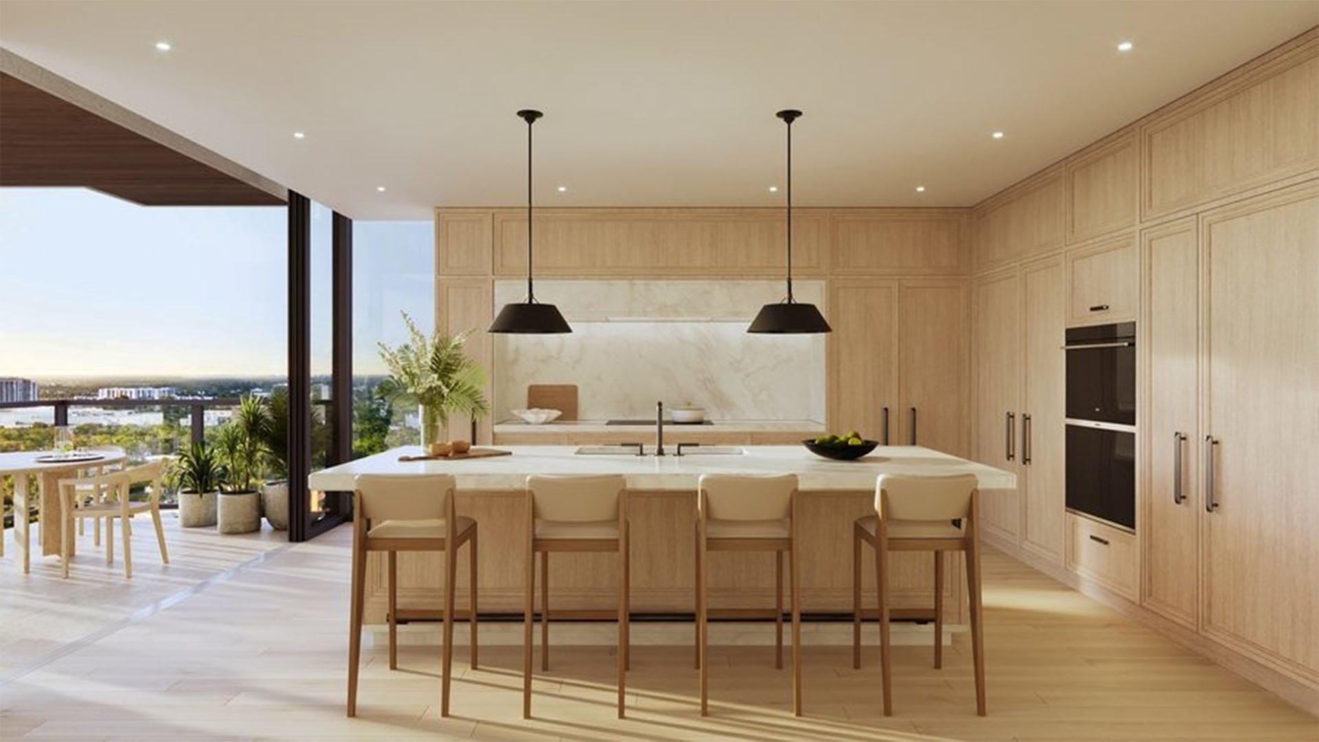 Chef kitchen at The Ritz-Carlton Residences, Fort Lauderdale, featuring an oversized island, custom wood cabinetry, and an open terrace with water views in one of the luxury and ultra luxury condos.