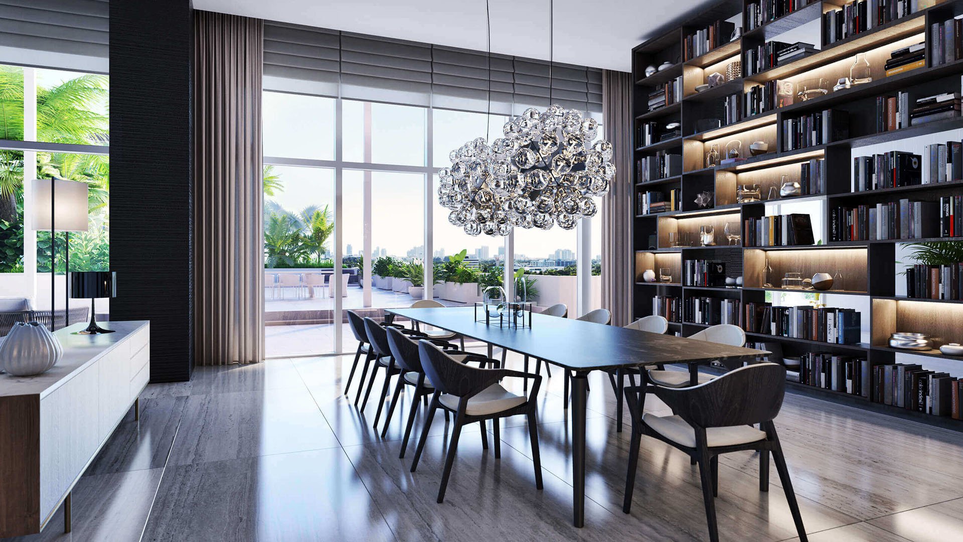 Dining room with a full-height library wall, sculptural chandelier and terrace access at The Ritz-Carlton Residences Miami Beach in Miami Beach, inside the luxury and ultra luxury condos.