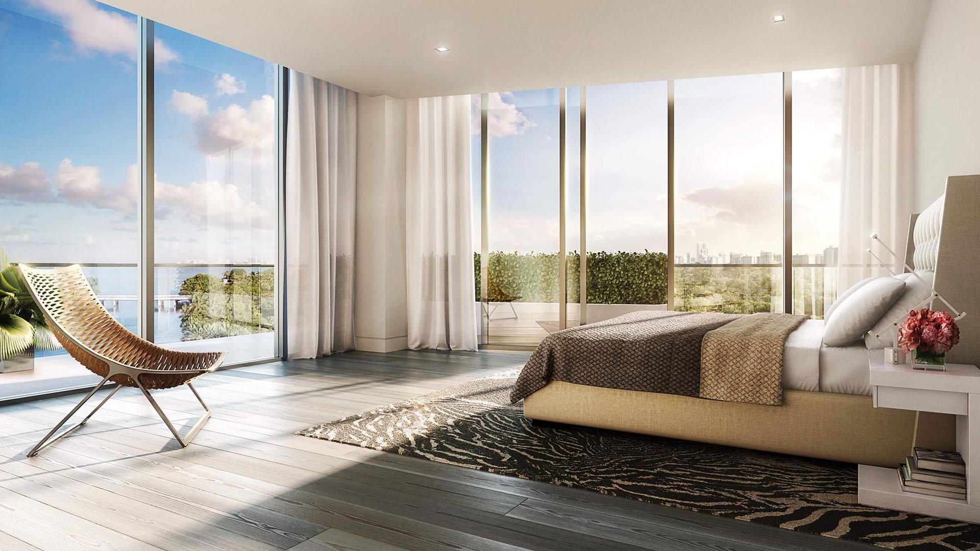 Primary bedroom with corner glass, terrace access and waterfront views at The Ritz-Carlton Residences Miami Beach in Miami Beach, inside the luxury and ultra luxury condos.