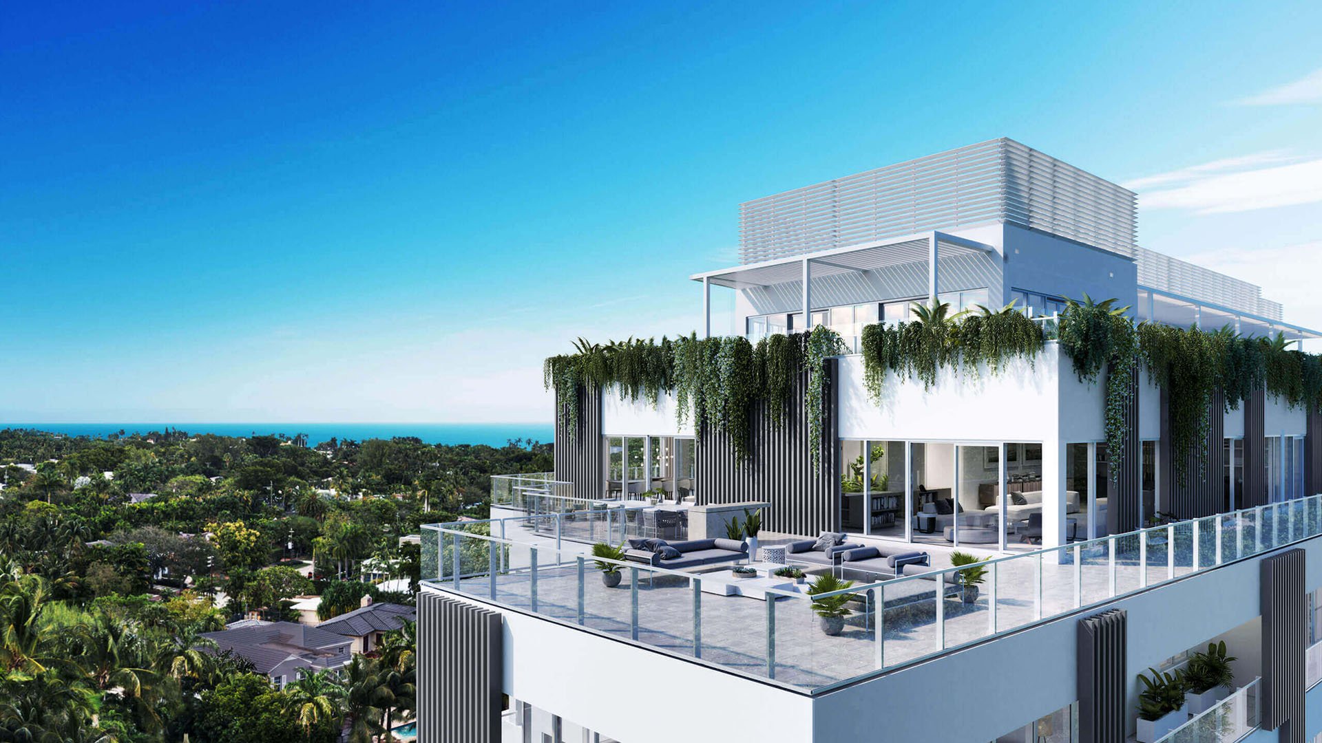 Expansive rooftop penthouse terrace at The Ritz-Carlton Residences Miami Beach in Miami Beach, showing luxury and ultra luxury condos with glass railings, lounge seating and a distant ocean horizon.