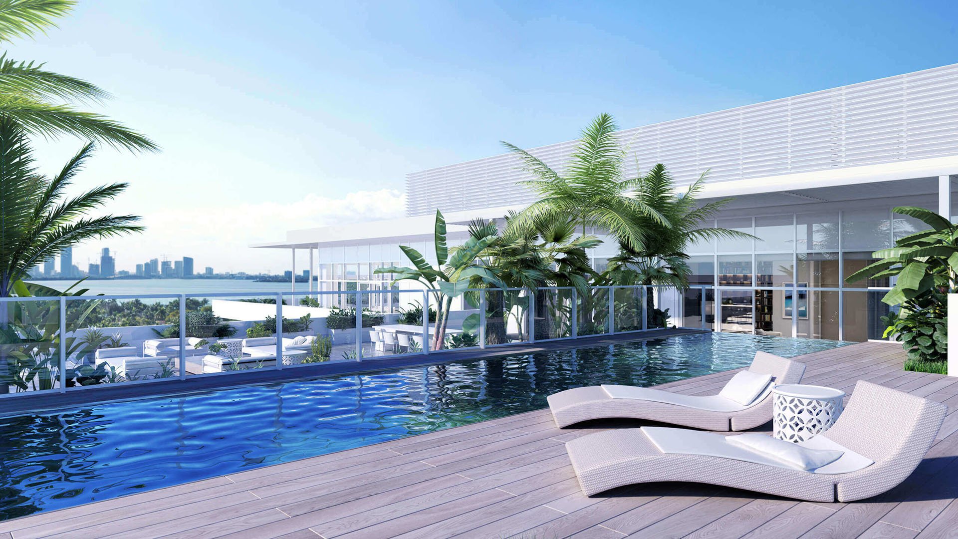 Rooftop pool terrace with palm plantings, chaise loungers and skyline views at The Ritz-Carlton Residences Miami Beach in Miami Beach, an amenity for the luxury and ultra luxury condos.