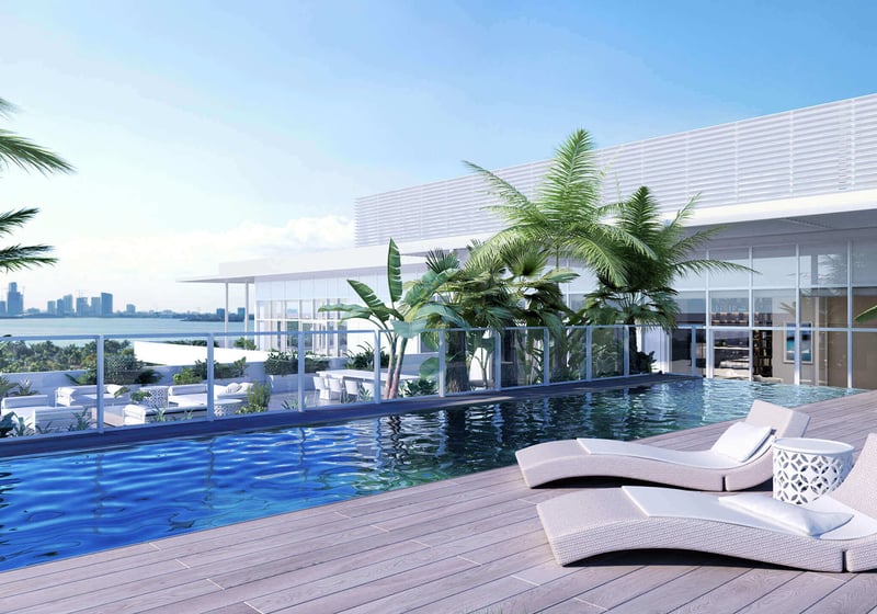Rooftop pool terrace with palm plantings, chaise loungers and skyline views at The Ritz-Carlton Residences Miami Beach in Miami Beach, an amenity for the luxury and ultra luxury condos.