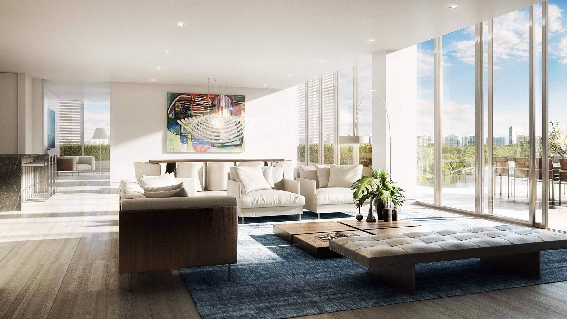 Sunlit living room with corner glass walls, terrace seating and water views at The Ritz-Carlton Residences Miami Beach in Miami Beach, inside the luxury and ultra luxury condos.