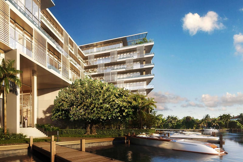 Waterfront exterior with a private dock and speedboat at The Ritz-Carlton Residences Miami Beach in Miami Beach, showing luxury and ultra luxury condos along the water.