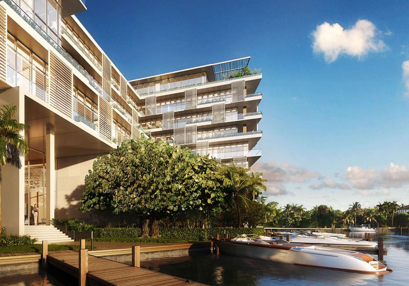 Waterfront exterior with a private dock and speedboat at The Ritz-Carlton Residences Miami Beach in Miami Beach, showing luxury and ultra luxury condos along the water.