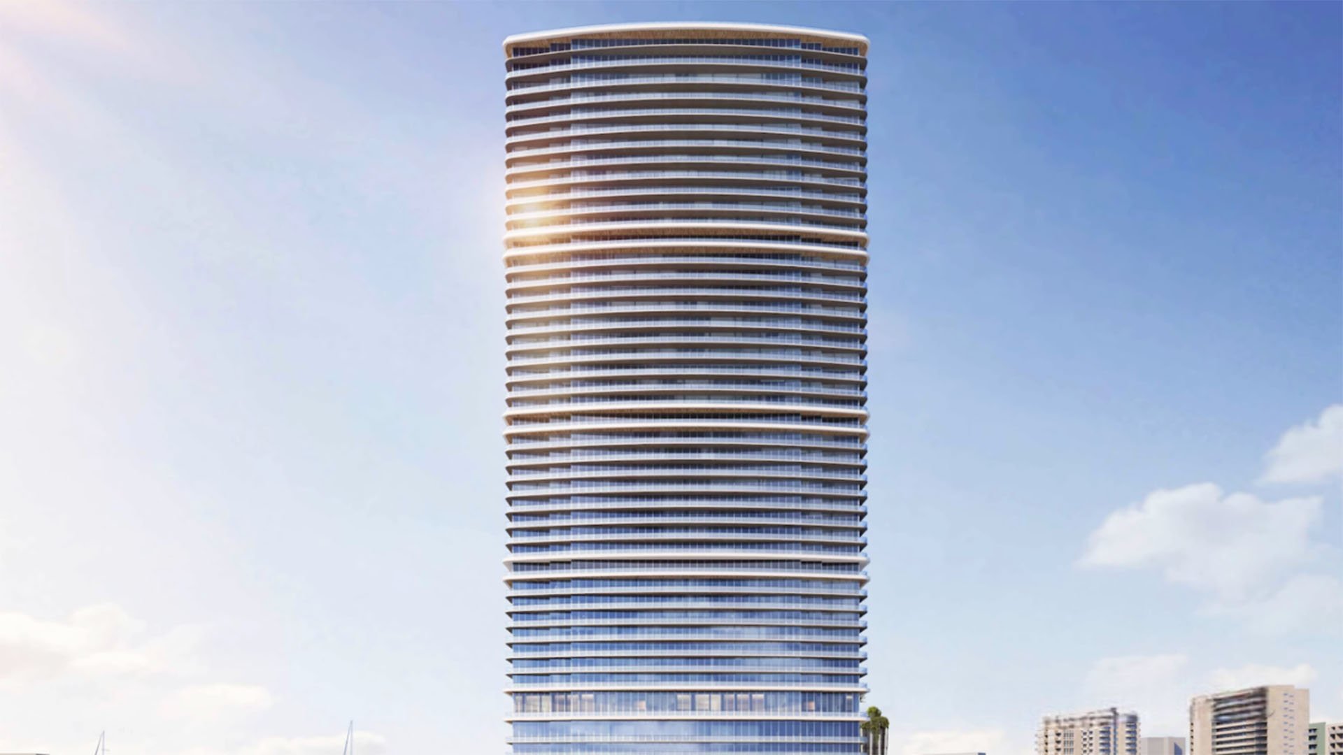 Front elevation of a tall curved glass tower at The Ritz-Carlton Residences, North Bay Village, highlighting the sleek facade of luxury and ultra luxury condos in this preconstruction waterfront development.