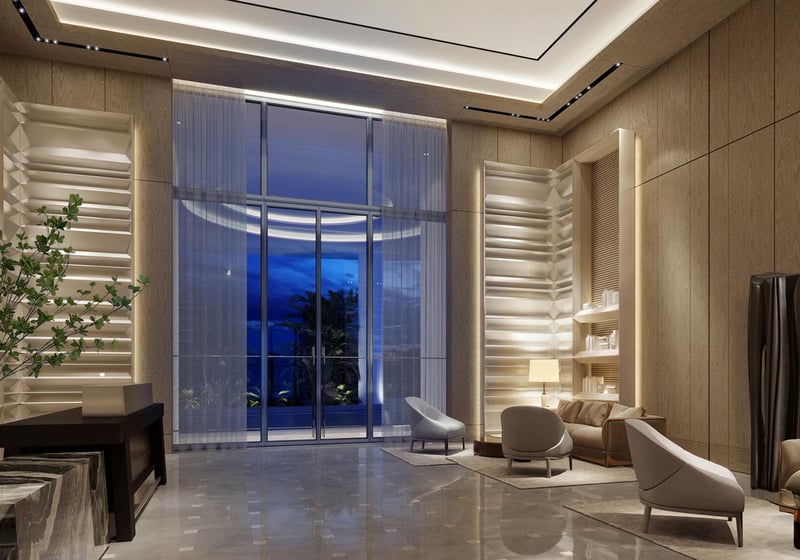 Double-height residential lobby with warm wood paneling and modern lounge seating at The Ritz-Carlton Residences Palm Beach Gardens, Palm Beach Gardens, Florida, highlighting luxury and ultra luxury preconstruction condos with refined finishes.
