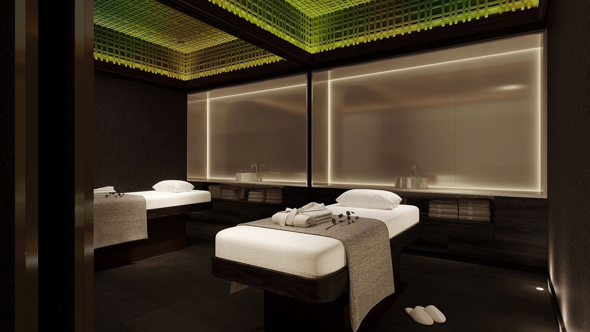 Luxury spa treatment room with dual massage tables, ambient LED lighting and dark wood finishes at The Ritz-Carlton Residences Palm Beach Gardens, Palm Beach Gardens, Florida, highlighting ultra luxury preconstruction condos wellness amenities.