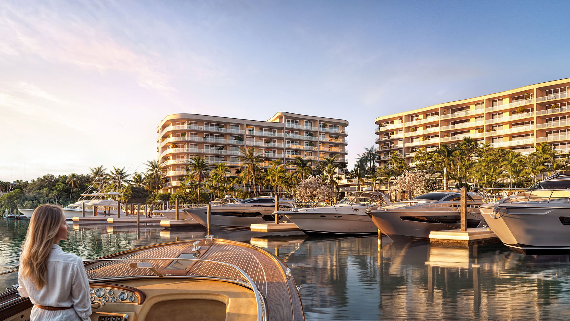 Sunset marina view with yachts at private docks in front of The Ritz-Carlton Residences Palm Beach Gardens, Palm Beach Gardens, Florida, showcasing luxury and ultra luxury preconstruction condos with waterfront lifestyle on the Intracoastal Waterway.