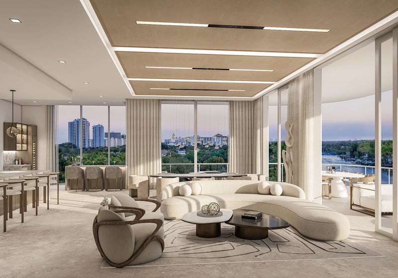 The Ritz-Carlton Residences Palm Beach Gardens Residence A open-concept living and kitchen with curved sectional, marble island and floor-to-ceiling windows opening to a waterfront balcony in Palm Beach Gardens, Florida. Luxury, ultra luxury preconstruction condos.