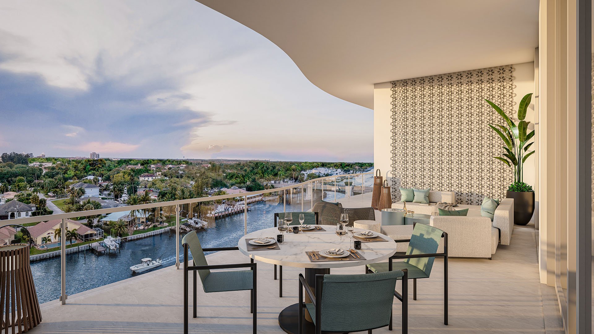 The Ritz-Carlton Residences Palm Beach Gardens Residence B north balcony with outdoor dining round table, lounge seating and glass railing overlooking waterfront at sunset, Palm Beach Gardens, Florida. Luxury, ultra luxury preconstruction condos.