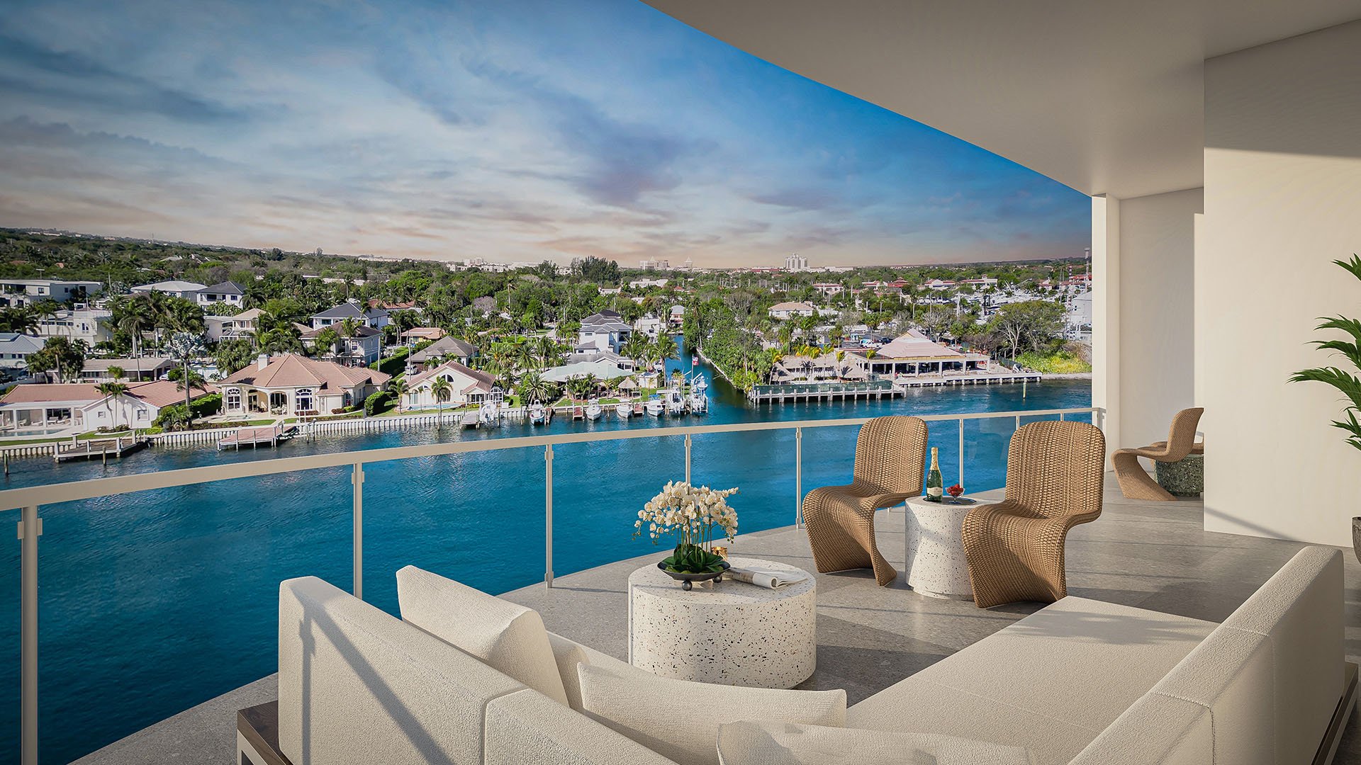 Residence F east building balcony with white sectional, woven chairs and bright Intracoastal Waterway view at The Ritz-Carlton Residences, Palm Beach Gardens, Florida, highlighting luxury and ultra luxury preconstruction condos.