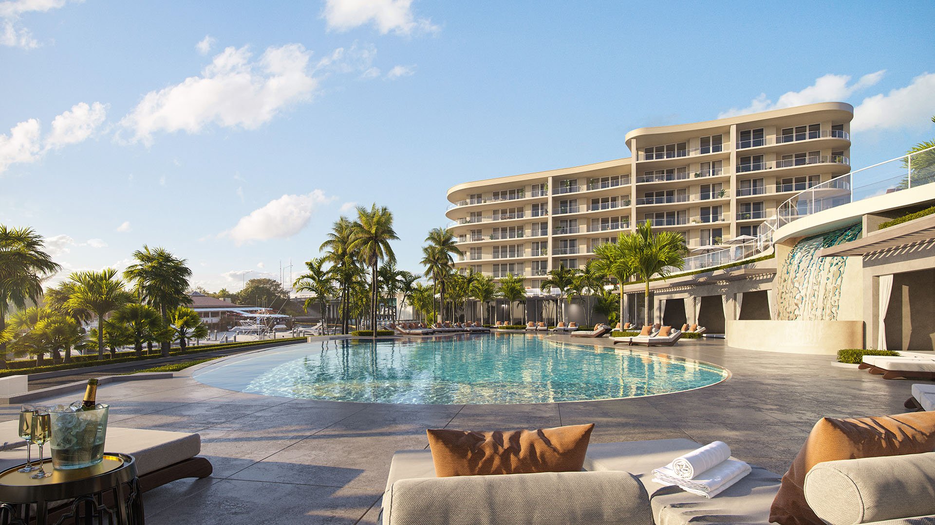 The Ritz-Carlton Residences, Palm Beach Gardens FL resort-style waterfront pool with cabanas, sun loungers and signature waterfall wall, amenity for luxury and ultra luxury preconstruction condos.