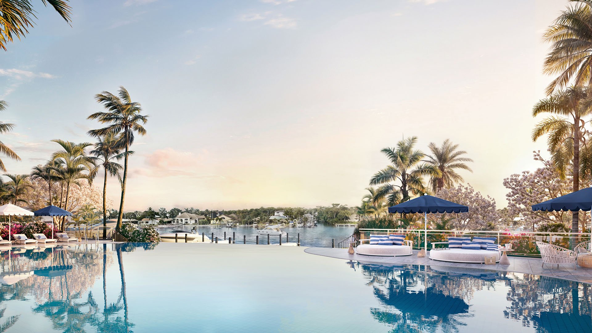 The Ritz-Carlton Residences, Palm Beach Gardens FL waterfront infinity pool with cabanas, blue umbrellas and sunset river views, resort amenity for luxury and ultra luxury preconstruction condos.