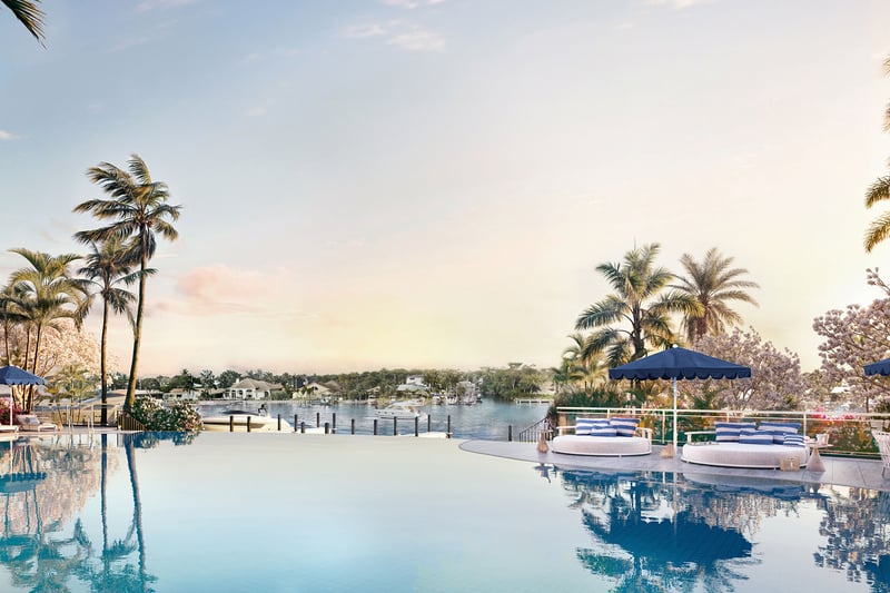 The Ritz-Carlton Residences, Palm Beach Gardens FL waterfront infinity pool with cabanas, blue umbrellas and sunset river views, resort amenity for luxury and ultra luxury preconstruction condos.