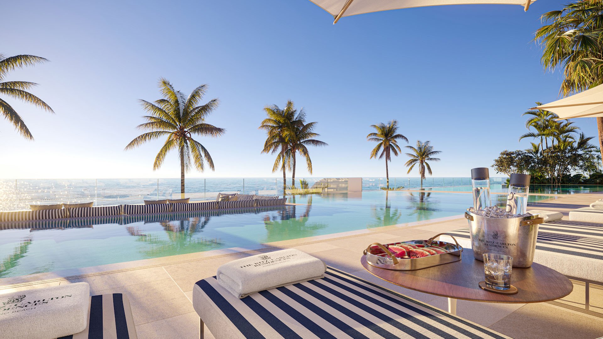 Infinity pool deck at The Ritz-Carlton Residences Pompano Beach, Florida Beach Tower, with striped loungers, cabanas and panoramic Atlantic views, showcasing luxury and ultra luxury preconstruction condos resort-style amenities.