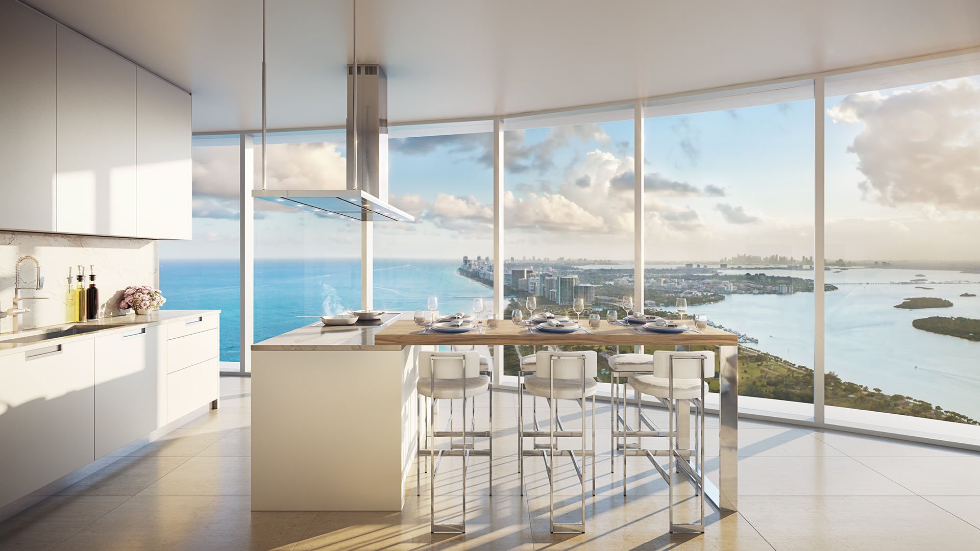 White chef kitchen with island seating and panoramic water views at The Ritz-Carlton Residences, Sunny Isles Beach, luxury and ultra luxury condos in Sunny Isles Beach.