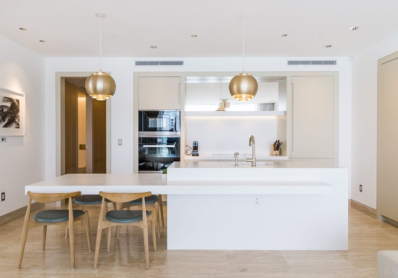 Front-facing chef kitchen with island breakfast bar, pendant lighting, and integrated appliances at The Surf Club Four Seasons, Fort Lauderdale luxury and ultra luxury condos.