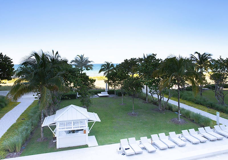 Elevated view of the oceanfront lawn, cabana, and rows of sun loungers at The Surf Club Four Seasons, Fort Lauderdale luxury and ultra luxury condos.