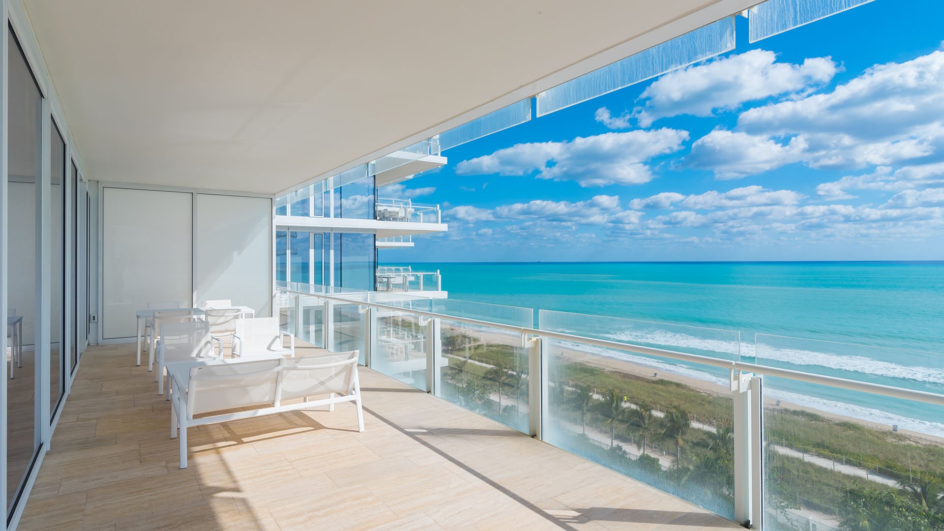 Wraparound oceanfront balcony with chaise lounges, glass railings, and expansive water views at The Surf Club Four Seasons, Fort Lauderdale luxury and ultra luxury condos.