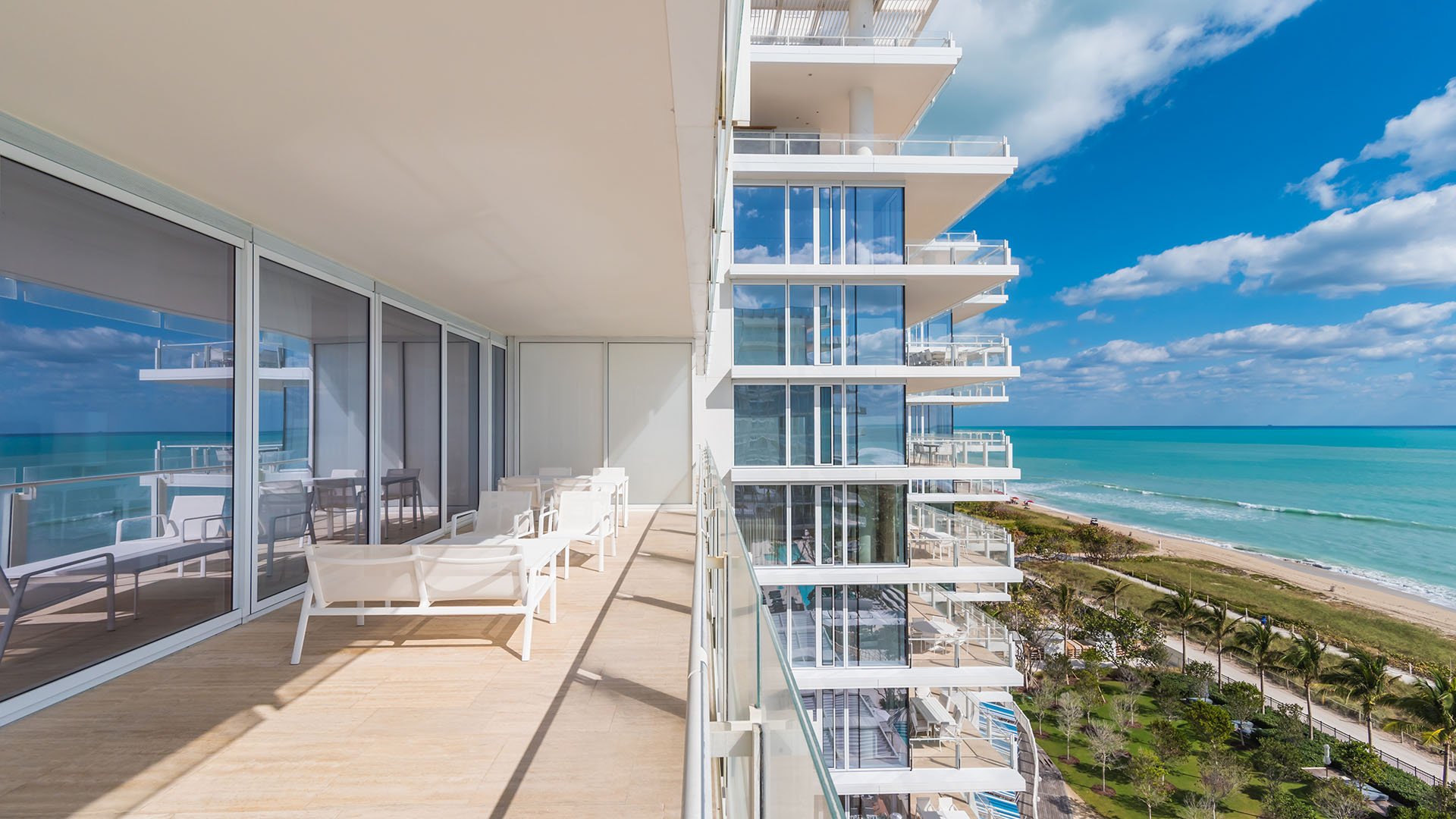 Wraparound terrace running beside the tower with lounge chairs and open ocean views at The Surf Club Four Seasons, Fort Lauderdale luxury and ultra luxury condos.