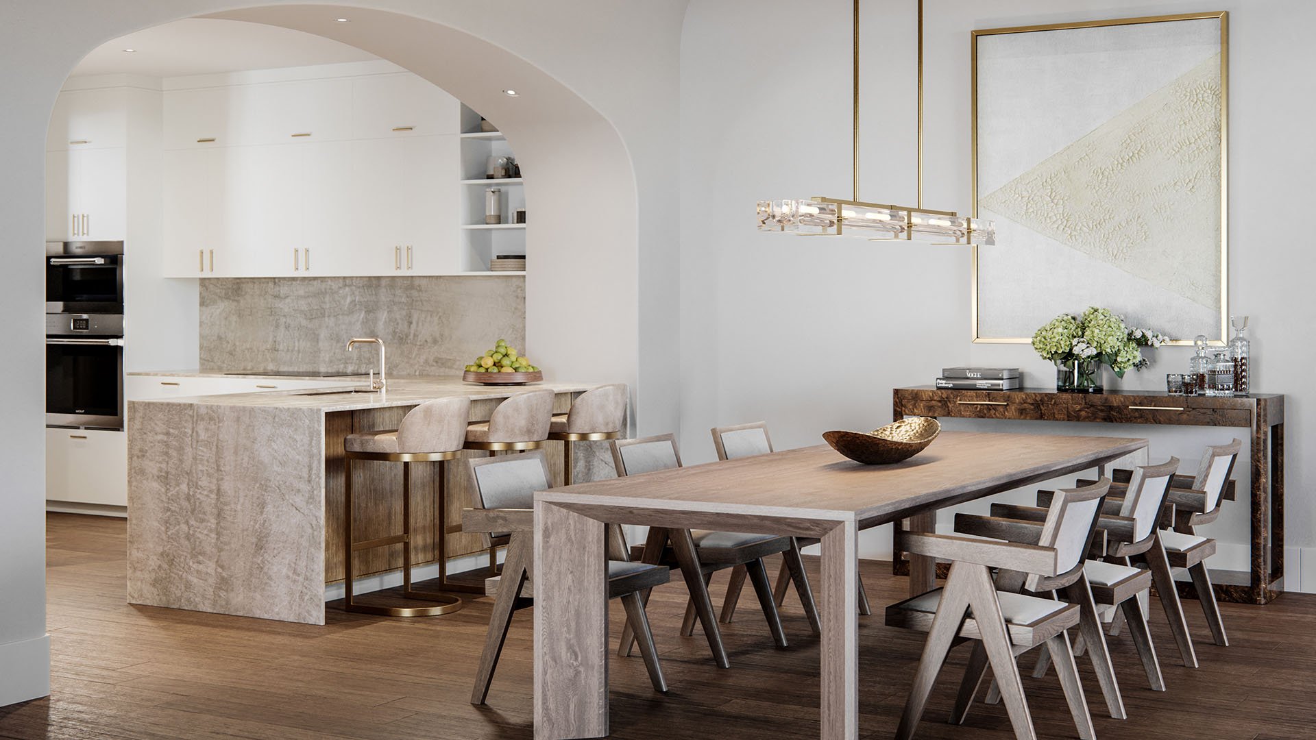 The Village at Coral Gables open-concept kitchen and dining in Coral Gables, Miami with arched entry, stone island and bar stools, designer chandelier and long table; luxury and ultra luxury preconstruction condos.