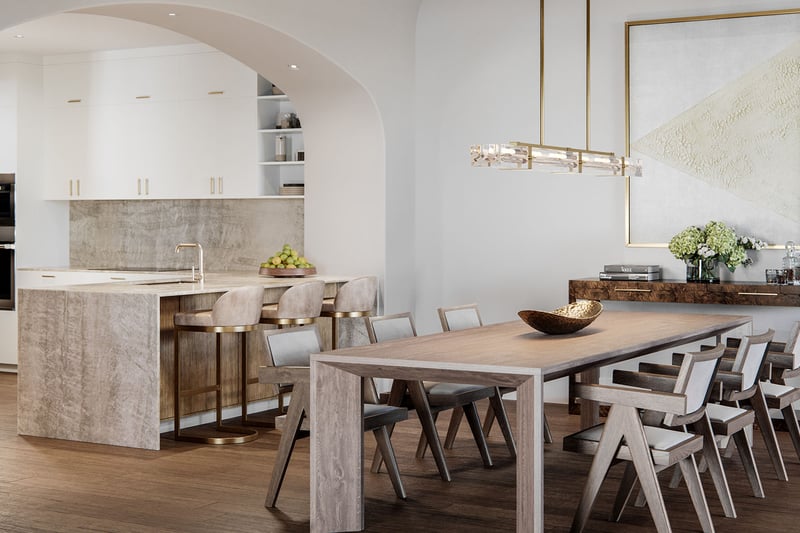 The Village at Coral Gables open-concept kitchen and dining in Coral Gables, Miami with arched entry, stone island and bar stools, designer chandelier and long table; luxury and ultra luxury preconstruction condos.