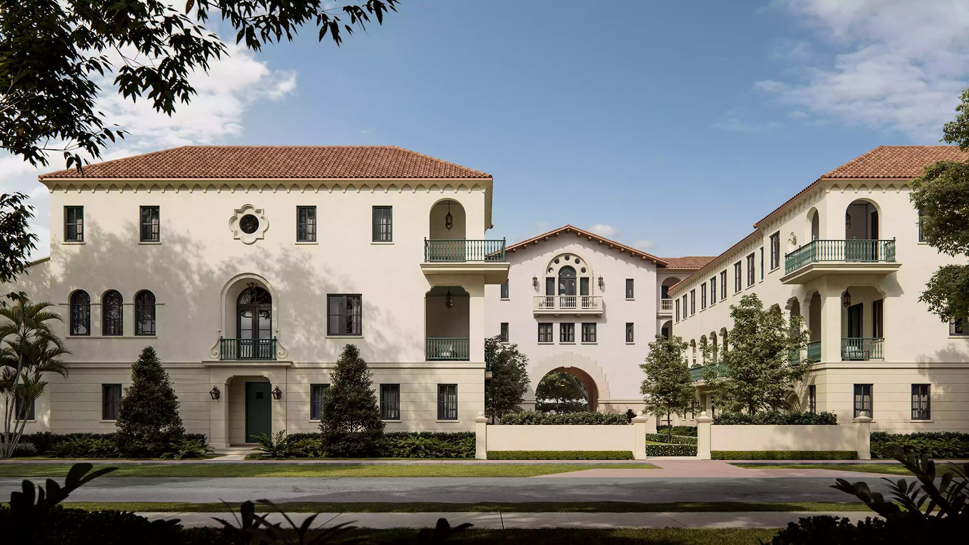 The Village at Coral Gables in Coral Gables, Miami daytime street view of Spanish Mediterranean village with balconies, arched entry and landscaped courtyards; luxury and ultra luxury preconstruction condos.