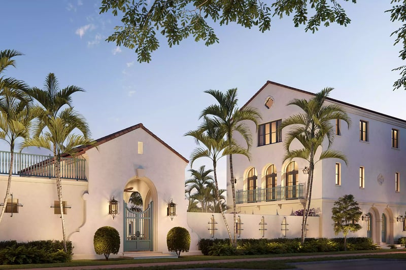 The Village at Coral Gables entry gate in Coral Gables, Miami at sunset with palm-lined Spanish Mediterranean buildings, arched windows and balcony railings; luxury and ultra luxury preconstruction condos.