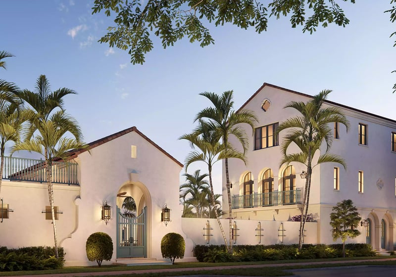 The Village at Coral Gables entry gate in Coral Gables, Miami at sunset with palm-lined Spanish Mediterranean buildings, arched windows and balcony railings; luxury and ultra luxury preconstruction condos.
