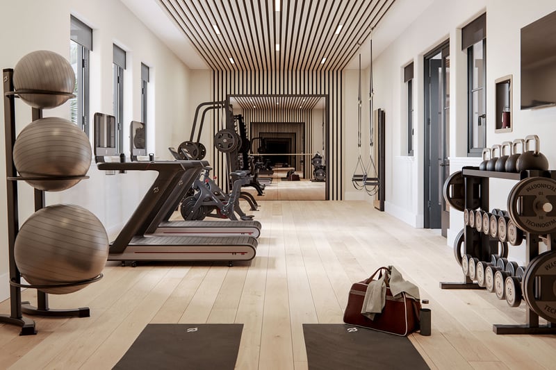 The Village at Coral Gables fitness center in Coral Gables, Miami with treadmills, bikes, free weights, mirrors and slat ceiling; luxury and ultra luxury preconstruction condos wellness amenity.