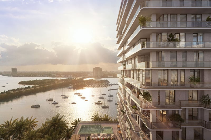 Aerial bayfront view of the tower and surrounding shoreline at Tula Residences in North Bay Village, showcasing luxury and ultra luxury condos with curved terraces, waterfront positioning, and a prominent coastal skyline presence.
