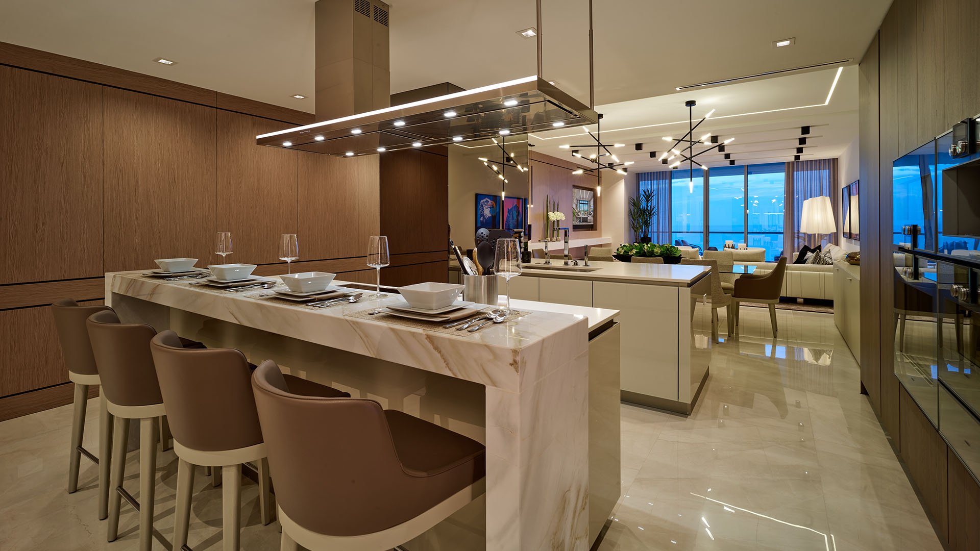 Turnberry Ocean Club in Sunny Isles Beach luxury and ultra luxury condos showcase a chef kitchen with a long island, bar seating, and a wide view into the living room.