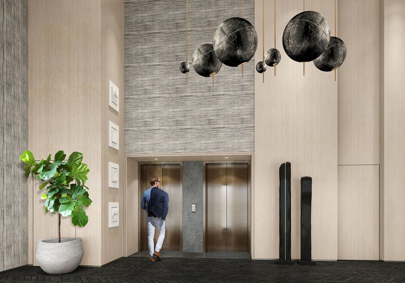 Turnberry Ocean Club in Sunny Isles Beach luxury and ultra luxury condos showcase a double-height elevator lobby with oversized pendant lights, textured walls, and stone flooring.