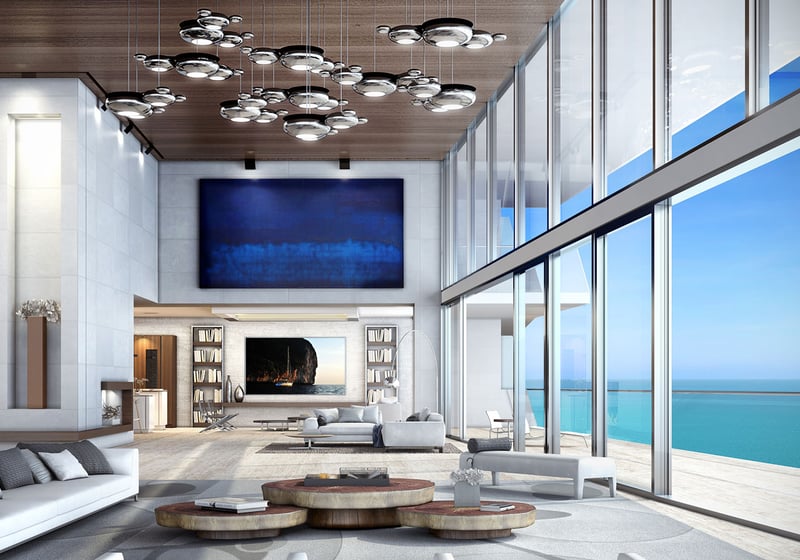 Turnberry Ocean Club in Sunny Isles Beach luxury and ultra luxury condos showcase a double-height living room with a vast ocean terrace, tall glazing, and layered lounge seating.