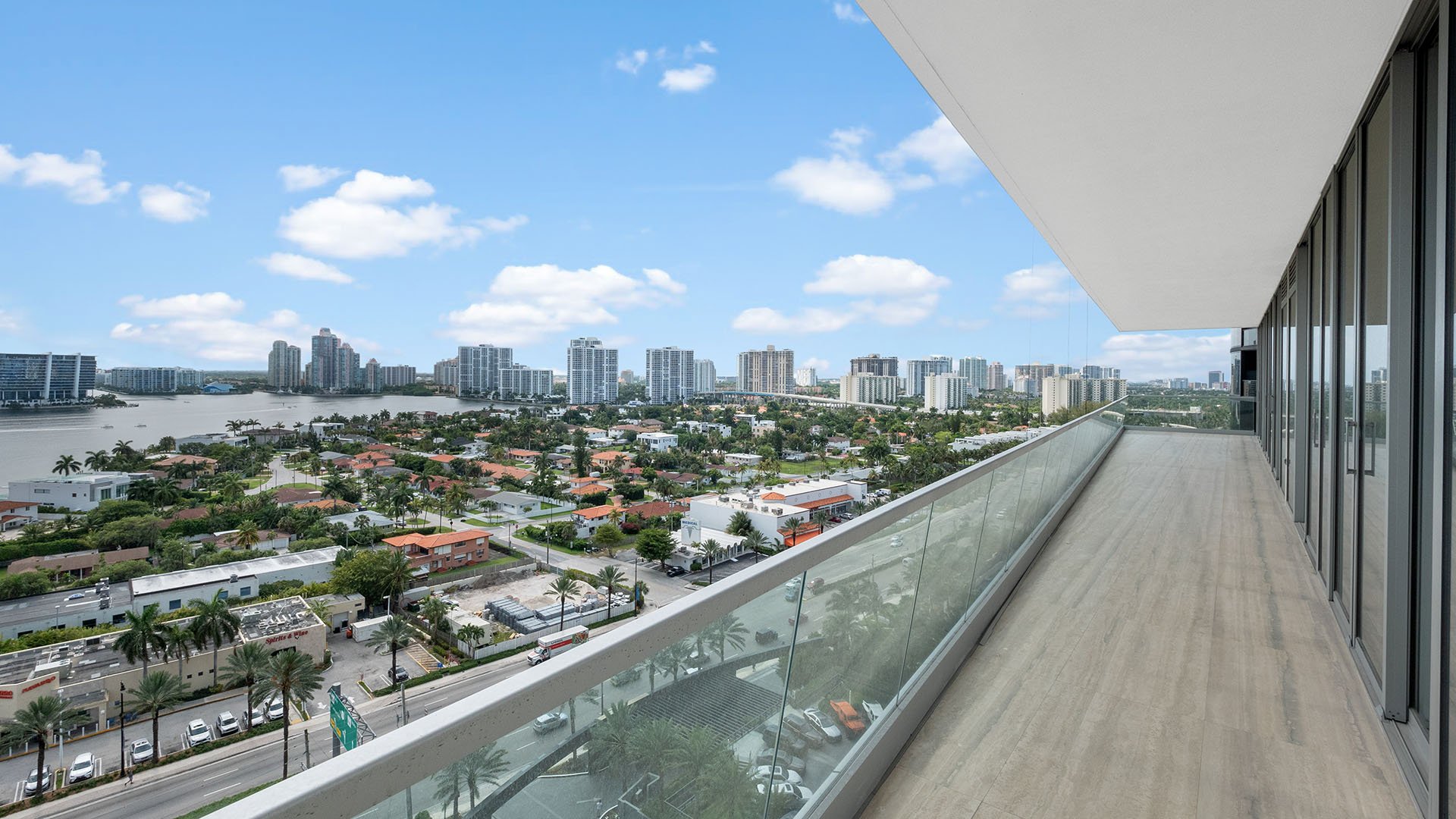Turnberry Ocean Club in Sunny Isles Beach luxury and ultra luxury condos showcase a long glass balcony with city skyline and bay views under a cantilevered overhang.