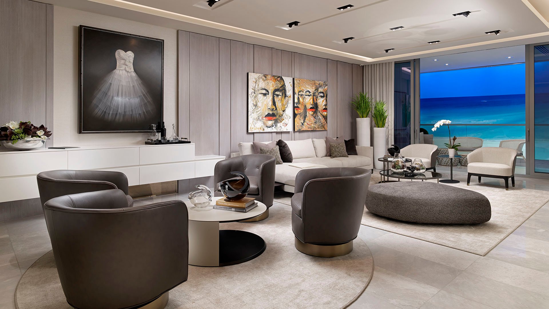 Turnberry Ocean Club in Sunny Isles Beach luxury and ultra luxury condos showcase a twilight living room with ocean views, lounge seating, and a curated gallery wall.