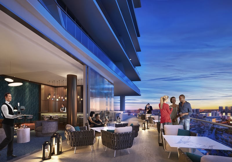 Turnberry Ocean Club in Sunny Isles Beach luxury and ultra luxury condos showcase a sunset lounge terrace with outdoor seating, service staff, and skyline views at dusk.