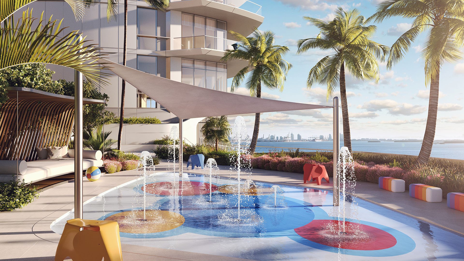 Una Residences Brickell, Miami kids splash pad with water jets, shade canopy, palm trees and bayfront setting, part of the luxury and ultra luxury preconstruction condos amenity deck on Biscayne Bay.