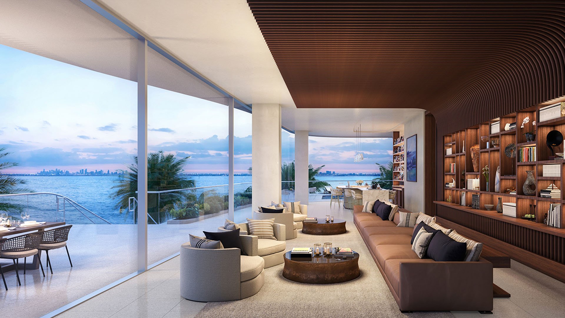 Una Residences Brickell, Miami residents lounge with library wall, curved wood slat ceiling and terrace overlooking Biscayne Bay, representing luxury and ultra luxury preconstruction condos with indoor-outdoor social spaces.