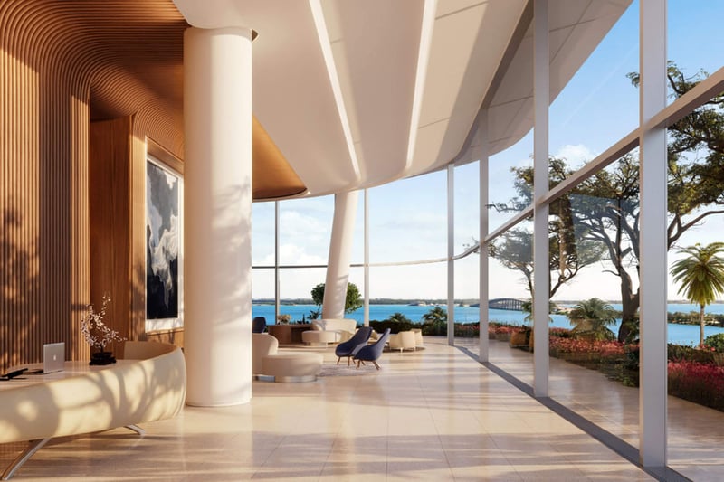 Una Residences Brickell, Miami grand lobby reception with sculptural curved architecture, wood accents and floor-to-ceiling glass overlooking waterfront, setting the tone for luxury and ultra luxury preconstruction condos.