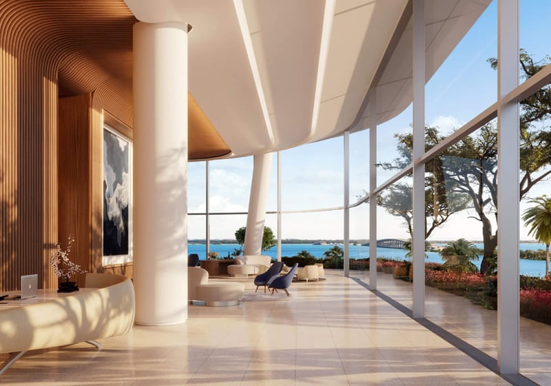 Una Residences Brickell, Miami grand lobby reception with sculptural curved architecture, wood accents and floor-to-ceiling glass overlooking waterfront, setting the tone for luxury and ultra luxury preconstruction condos.