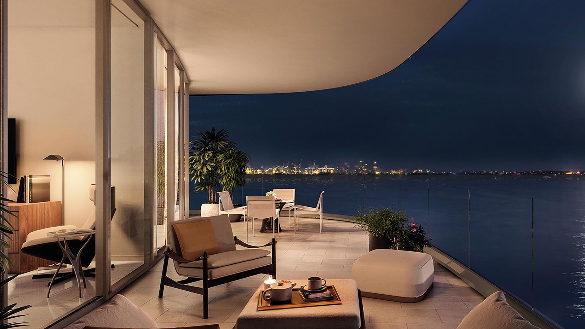 Una Residences Brickell, Miami private terrace at night with outdoor lounge and dining, glass railing and waterfront city lights, enhancing luxury and ultra luxury preconstruction condos with indoor-outdoor living.
