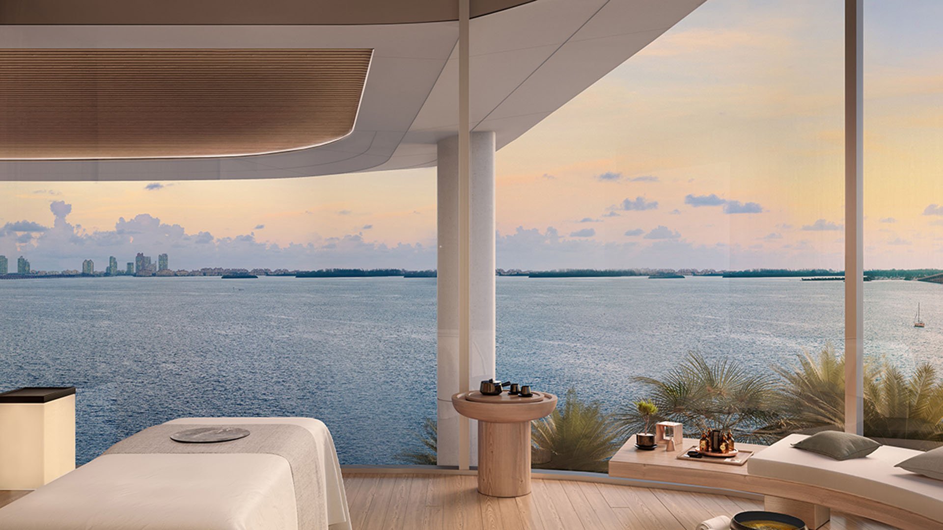 Una Residences Brickell, Miami spa treatment room with massage bed, relaxation chaise and floor-to-ceiling bay views, part of luxury and ultra luxury preconstruction condos wellness amenities overlooking Biscayne Bay.