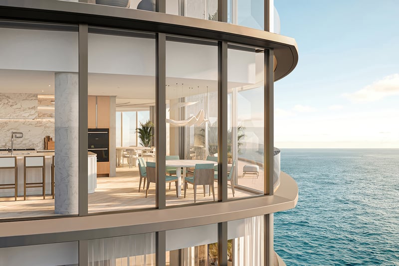 Upper Penthouse Rivage in Bal Harbour luxury and ultra luxury condos curved glass exterior showing a chef kitchen and dining area beside wraparound ocean views.